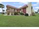 Exterior view of the condo building with a grassy area and landscaping at 66 Boundary Blvd # 282, Rotonda West, FL 33947