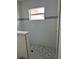 Modern bathroom featuring mosaic tiled shower with window, neutral colors, and sleek fixtures at 7351 Lighthouse St, Englewood, FL 34224