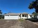 New construction home boasts a three-car garage, stucco exterior, and neutral color palette at 7351 Lighthouse St, Englewood, FL 34224