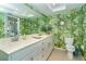 Clean bathroom with double sinks, a toilet, and tropical wallpaper at 7482 Palm Island Dr # 2511, Placida, FL 33946