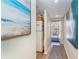 Bright hallway with beach-themed art, leading to a private balcony at 7482 Palm Island Dr # 2511, Placida, FL 33946