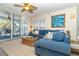 Bright living room with sectional sofa, balcony access, and ceiling fan at 7482 Palm Island Dr # 2511, Placida, FL 33946