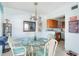Dining area with glass-top table, light-colored wicker chairs, and coastal decor at 84 Boundary Blvd # 165, Rotonda West, FL 33947