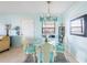 Dining room with a round glass table, wicker chairs, and access to the kitchen at 84 Boundary Blvd # 165, Rotonda West, FL 33947