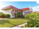 Exterior view of a two-story condo building with a red roof, balconies, and landscaped grounds at 84 Boundary Blvd # 165, Rotonda West, FL 33947