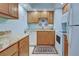 Compact kitchen with light wood cabinetry, granite countertops, and white appliances at 84 Boundary Blvd # 165, Rotonda West, FL 33947