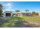 Rear view of a home showcasing a detached garage and covered patio at 9230 Griggs Rd, Englewood, FL 34224