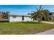 Front view of a charming single story home with palm tree at 9230 Griggs Rd, Englewood, FL 34224