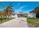 House exterior with palm tree, driveway, and detached garage at 9230 Griggs Rd, Englewood, FL 34224