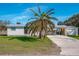 Front view of a single-story home with palm tree and driveway at 9230 Griggs Rd, Englewood, FL 34224