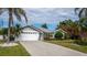 Single-story home with a white garage door and landscaped yard at 9276 San Bernandino Ave, Englewood, FL 34224