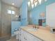 Bathroom with light blue walls, walk-in shower, and vanity at 9567 Honeymoon Dr, Port Charlotte, FL 33981
