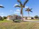 Single-story home with palm trees and a well-maintained lawn at 9567 Honeymoon Dr, Port Charlotte, FL 33981