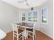 Cozy dining area with a charming table, white chairs, and large windows with shutters at 112 Abercrombie Ave, Englewood, FL 34223