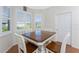 Inviting dining space with a wood table, white chairs, and abundant natural light at 112 Abercrombie Ave, Englewood, FL 34223