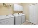 Bright laundry room with washer, dryer, and ample cabinetry at 11241 Mc Dermott Ct, Englewood, FL 34223