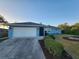 Light blue house with a white garage door and well-manicured landscaping at 1329 Sheehan Blvd, Port Charlotte, FL 33952