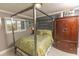 Bedroom with a metal canopy bed and wood dresser at 1401 S Mccall Rd # 306B, Englewood, FL 34223