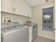 Laundry room with washer, dryer, and overhead cabinets at 14049 Willow Glen Ct # 242, Port Charlotte, FL 33953