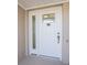 White front door with glass panel and crab door knocker at 17 Bunker Ct, Rotonda West, FL 33947