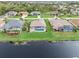 Aerial view showcases waterfront homes with private pools and screened patios bordering a wide canal at 171 Medalist Rd, Rotonda West, FL 33947