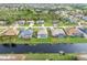 Aerial view of a canal-front neighborhood with homes featuring screened-in pools at 171 Medalist Rd, Rotonda West, FL 33947