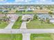 Aerial view of home by the canal surrounded by green grass and neighboring homes at 171 Medalist Rd, Rotonda West, FL 33947
