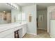 Bright bathroom featuring a spacious vanity, a large mirror, and a walk-in shower with glass doors at 171 Medalist Rd, Rotonda West, FL 33947