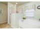 Bright bathroom showcasing a soaking tub with a shower, tiled floor, and fresh finishes at 171 Medalist Rd, Rotonda West, FL 33947