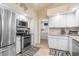 Bright kitchen with stainless steel appliances, white cabinetry, and tile floors, leading to the laundry room at 171 Medalist Rd, Rotonda West, FL 33947