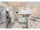 Well-lit kitchen with stainless steel appliances, tile backsplash, and ample counter space leading to laundry area at 171 Medalist Rd, Rotonda West, FL 33947