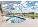 Relaxing screened-in pool with canal view and blue tiled trim at 171 Medalist Rd, Rotonda West, FL 33947