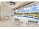Inviting screened-in pool area with canal view, ceiling fan, and outdoor dining set at 171 Medalist Rd, Rotonda West, FL 33947