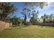 Large backyard with wooden fence and mature trees at 1860 Bluebird Ln, Englewood, FL 34224