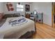 Bedroom with skull blanket, wood floors, and brick accent wall at 1860 Bluebird Ln, Englewood, FL 34224