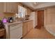 Bright kitchen features wood cabinets, white appliances, and access to backyard at 1860 Bluebird Ln, Englewood, FL 34224