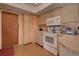 Kitchen boasts white appliances and wood cabinets at 1860 Bluebird Ln, Englewood, FL 34224