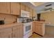 Kitchen with white appliances and wood cabinets at 1860 Bluebird Ln, Englewood, FL 34224