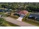Single-story home on a canal, surrounded by tropical foliage and other houses at 2397 Cannolot Blvd, Port Charlotte, FL 33948