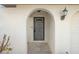 Front entrance with arched doorway, security door, and wall-mounted light at 2397 Cannolot Blvd, Port Charlotte, FL 33948