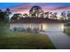 White single-story house with a red tile roof, a two-car garage, and well-manicured lawn at 2397 Cannolot Blvd, Port Charlotte, FL 33948