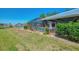 A green lawn leads to a screened-in pool enclosure on a waterfront lot at 26098 Constantine Rd, Punta Gorda, FL 33983