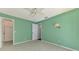 Bright bedroom with pale green walls, neutral carpet, and open closet at 26098 Constantine Rd, Punta Gorda, FL 33983