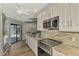 Bright, modern kitchen features white cabinetry, stainless steel appliances, and granite countertops at 26098 Constantine Rd, Punta Gorda, FL 33983
