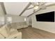 The living room with beamed ceiling, ceiling fan, and large TV at 26098 Constantine Rd, Punta Gorda, FL 33983