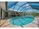 This pool with adjacent hot tub is screened-in and surrounded by a paved deck at 26098 Constantine Rd, Punta Gorda, FL 33983