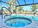 Close up of screened in pool area with spa and view of backyard lake and landscaping at 26098 Constantine Rd, Punta Gorda, FL 33983