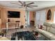 Living room with leather furniture, a ceiling fan, and peach-colored walls at 3150 10Th St, Englewood, FL 34224