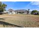 Backyard view featuring a large grassy area and a screened-in pool enclosure at 385 Pelican Bnd, Placida, FL 33946