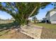 Spacious backyard with a large paver patio, mature trees, and lush landscaping at 385 Pelican Bnd, Placida, FL 33946